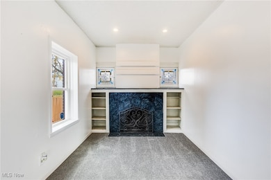 Unfurnished living room featuring carpet floors, a high end fireplace, and recessed lighting