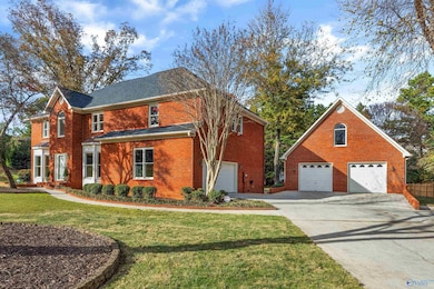 Two-story brick home with two car attached and 2 car detached garage.