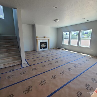 Unfurnished living room featuring a textured ceiling, stairway, a tile fireplace, and recessed lighting