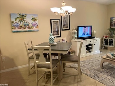Dining space with a chandelier and light tile floors