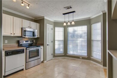 Bay window with wood blinds looks out onto the sunny patio.