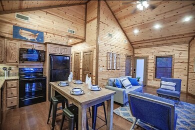 Dining space with high vaulted ceiling, wooden walls, wood ceiling, dark wood-type flooring, and a ceiling fan