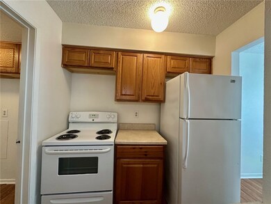 Kitchen featuring white appliances, brown cabinets