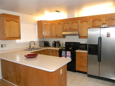 Convenient kitchen area features oak cabinetry, am