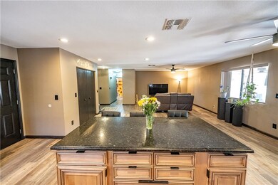 Kitchen with ceiling fan, baseboards, light wood-s
