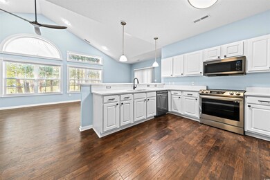 Kitchen featuring white cabinets, kitchen peninsula, and appliances with stainless steel finishes
