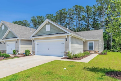 Craftsman house featuring an attached garage, stone siding, concrete driveway, a front lawn, and roof with shingles