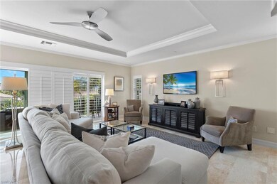 Living room with ceiling fan, a raised ceiling, an