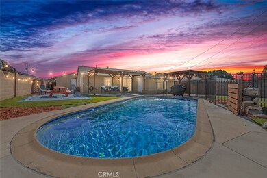 Entertainer’s dream backyard featuring a sparkling pool and a stylishly lit covered patio