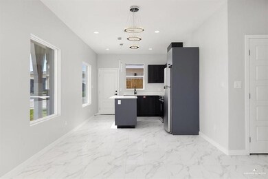 Kitchen with a center island, light marble finish floors, light countertops, pendant lighting, and a chandelier