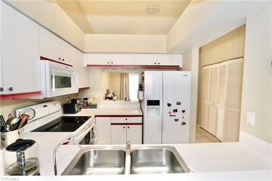 Kitchen with white appliances, a sink, light count