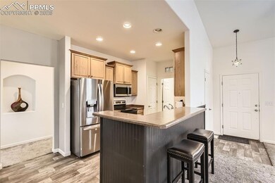 Kitchen with stainless steel appliances, light wood finished floors, a breakfast bar area, and recessed lighting