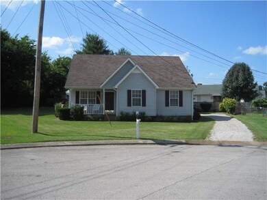 A second frontal view from a little farther away to show the driveway leading the spacious backyard.