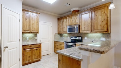 Kitchen featuring visible vents, a peninsula, brow