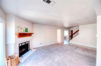 The living area has new carpet and painted brick f