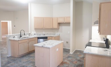 Kitchen featuring light stone counters, a peninsul