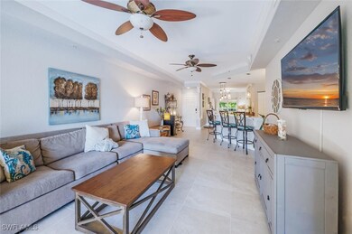 Living room featuring a ceiling fan and a raised ceiling