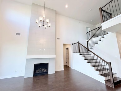 Unfurnished living room featuring stairs, a tower