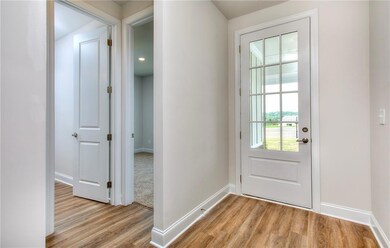 Doorway to outside featuring LVP floors and baseboards