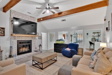 Living area featuring visible vents, a brick firep