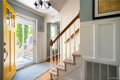 Entrance foyer with wood flooring, crown molding,