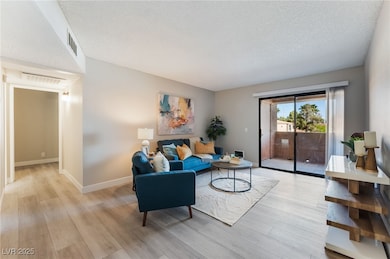 Living room with wood finished floors and a textured ceiling