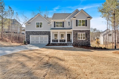 View of front facade with driveway, stone siding, 