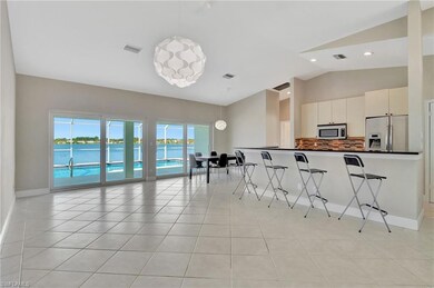 Kitchen with pendant lighting, white cabinets, app