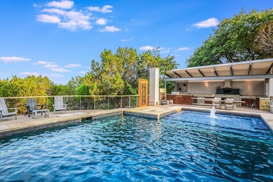 View of pool with an outdoor kitchen and a patio