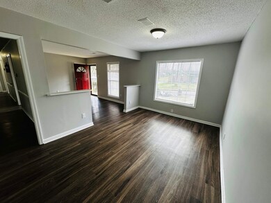 Empty room featuring a textured ceiling, dark wood