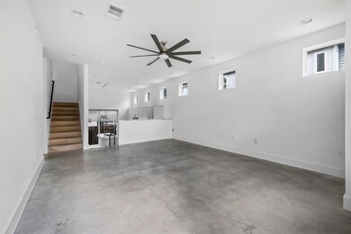 Unfurnished living room with a ceiling fan, concr