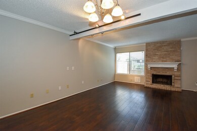 Living room boasts wood floors, crown molding, bri
