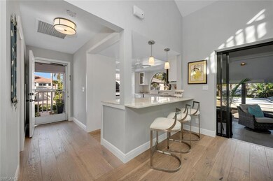 Kitchen featuring light hardwood / wood-style floors, a kitchen bar, kitchen peninsula, and hanging light fixtures