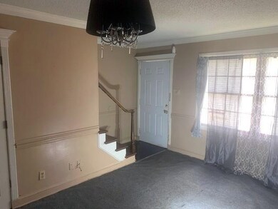 Carpeted entryway featuring a textured ceiling, stairs, a chandelier, and ornamental molding