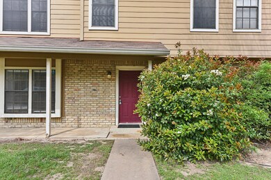 Doorway to property with a shingled roof and bric