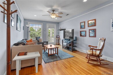 Living room featuring ceiling fan, light hardwood