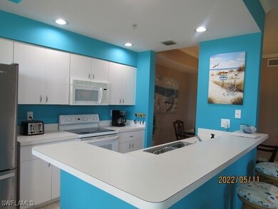 Kitchen featuring white appliances, a breakfast ba