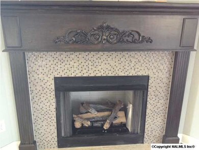 A stylish gas log fireplace accented with tile and a decorative hand made mantle adds beauty to the great room. With a flip of a wall switch, you will have your gas logs burning!