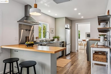 Kitchen featuring wooden counters, a peninsula, a kitchen bar, pendant lighting, and recessed lighting