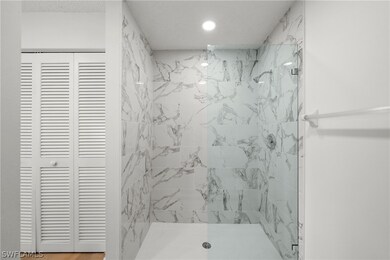Bathroom with a tile shower and wood-type flooring