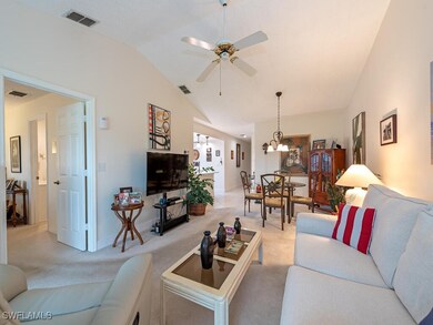 Living room with vaulted ceiling, light carpet, an