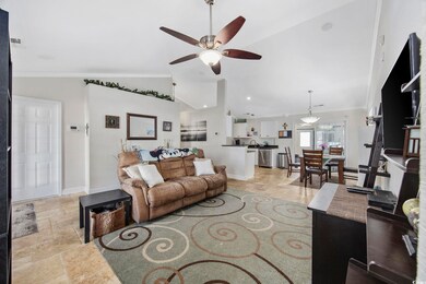 Living room featuring ceiling fan, crown molding, 