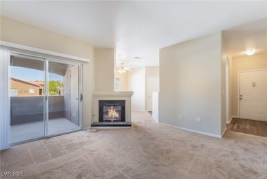 Unfurnished living room with light colored carpet, a glass covered fireplace, and ceiling fan
