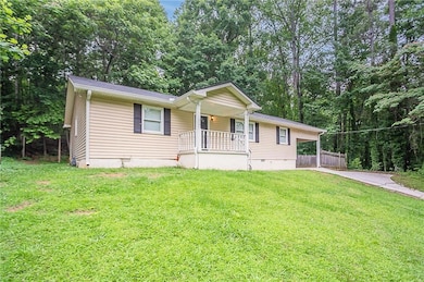 View of front of home with covered porch, driveway, crawl space, and a carport