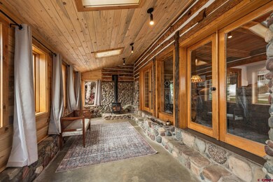 Huge mud room entrance with skylights, ample windows, and a wood stove.