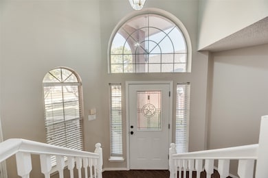 Entryway featuring a high ceiling, dark wood-style flooring, and a chandelier