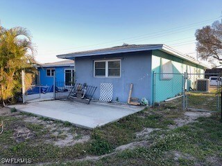 Rear view of property with central AC unit and a p