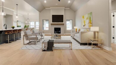 Spacious living room with vaulted ceilings, wood flooring, lots of natural lighting, wooden mantle, and a gas fireplace with designer tile surround.
