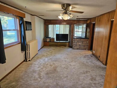 Unfurnished living room featuring ceiling fan, rad