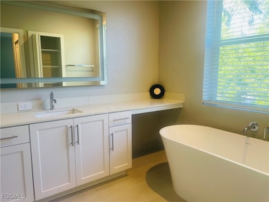 Bathroom with a soaking tub, vanity, and light tile patterned floors